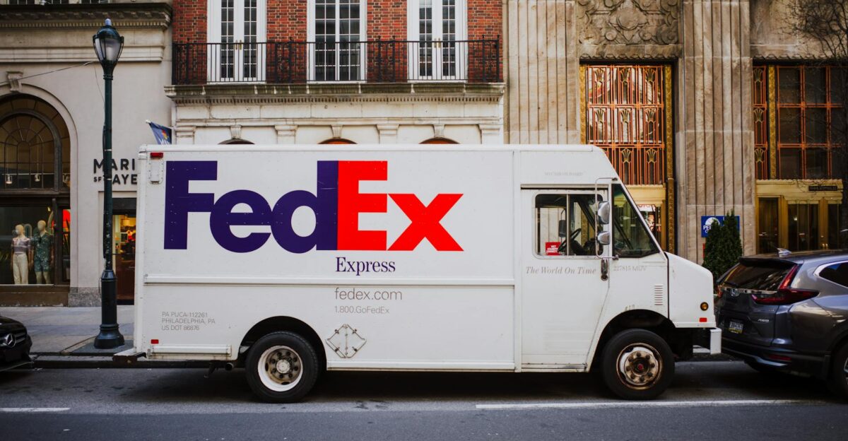 FedEx delivery truck parked on busy city street next to urban buildings