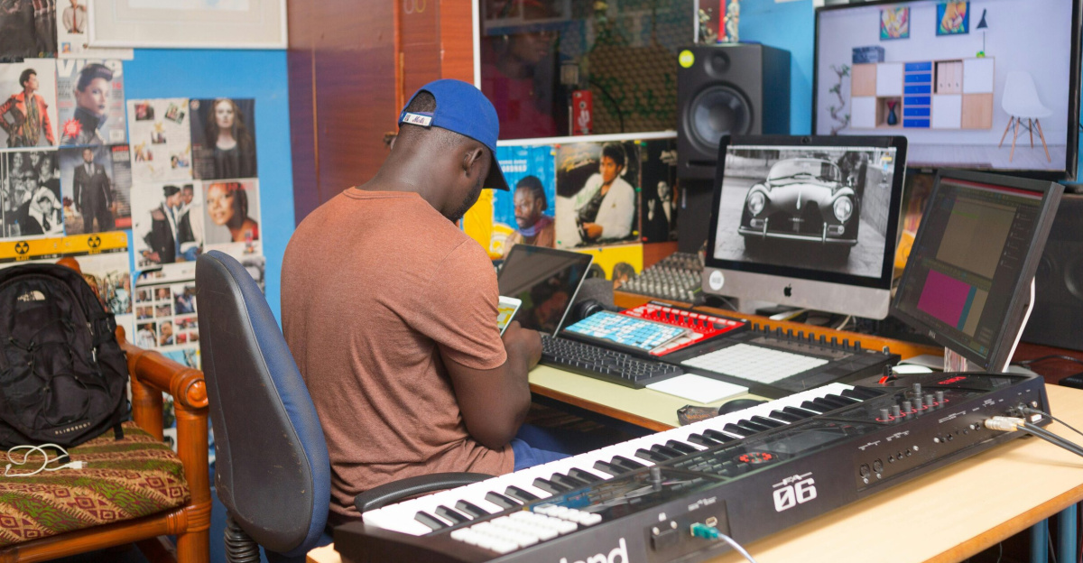 A man working at a modern music production studio with advanced equipment and colorful decor.