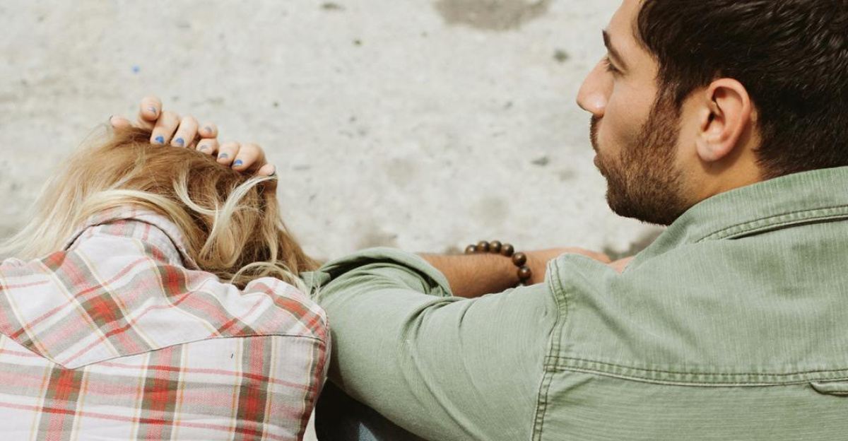 A couple sitting on the street, engaged in a distressed conversation, capturing a moment of emotional tension.