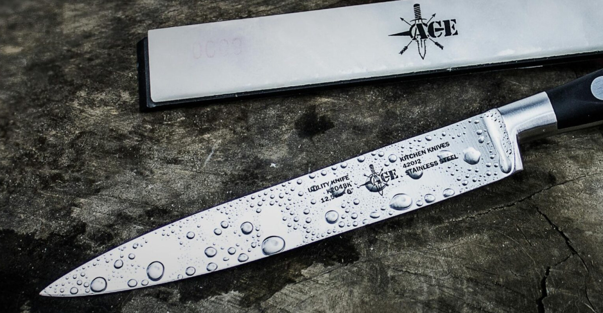 A sharp kitchen knife with water droplets on a rustic wooden surface, providing a dramatic mood.