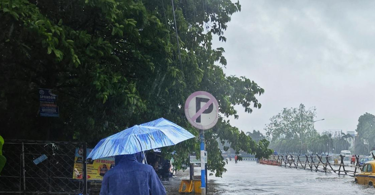 Street scene in Kolkata during monsoon flooding with pedestrian and cars