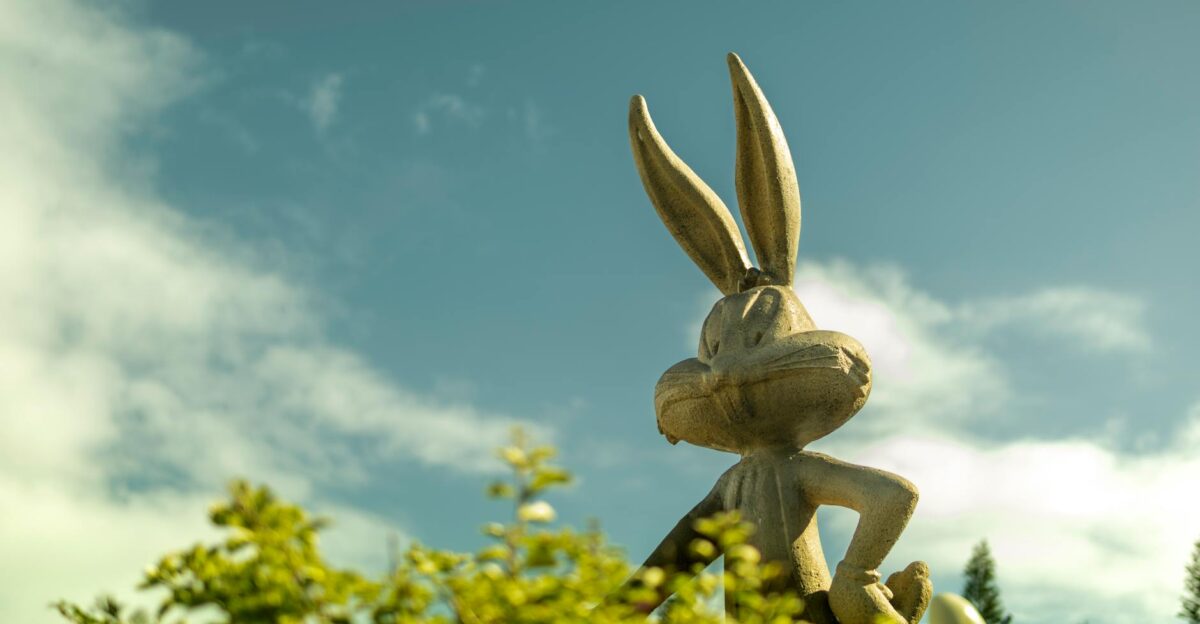 A whimsical Bugs Bunny statue set against a blue sky in a Gold Coast theme park