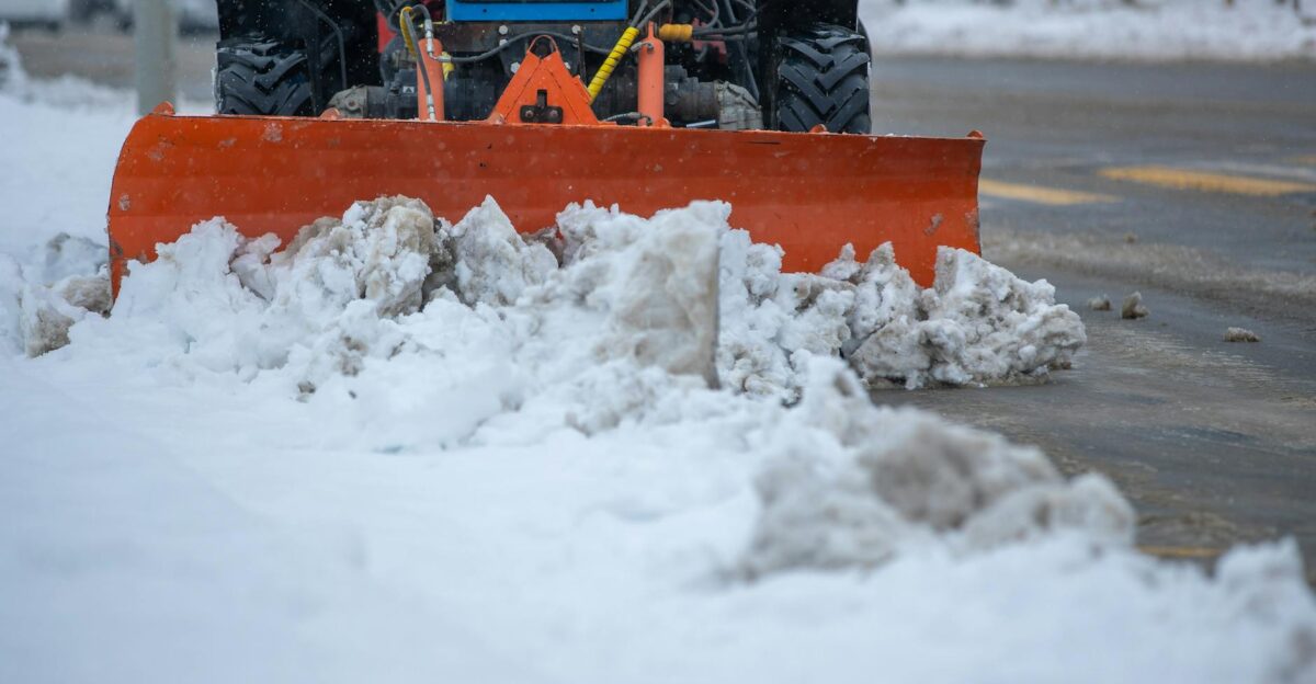 A snowplow clearing snow from a city street after a heavy winter snowstorm