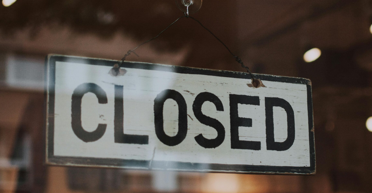 Classic closed sign hanging in front of a store window.