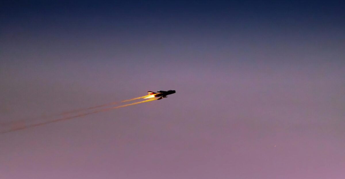 Captivating silhouette of a jet with afterburner against a dark twilight sky