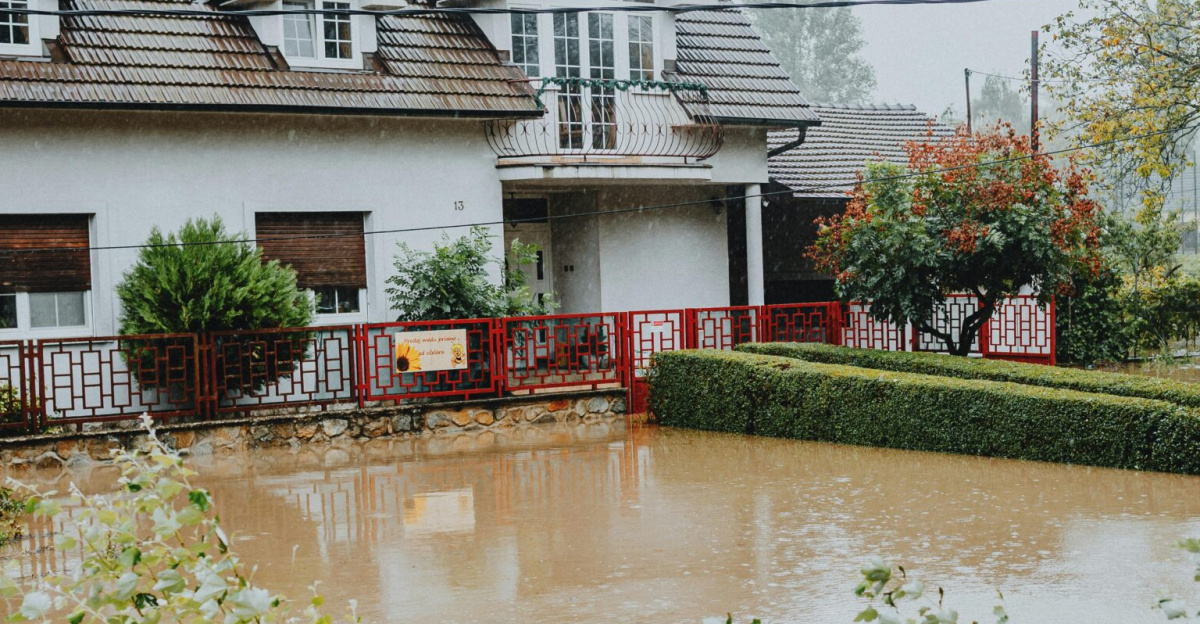 A suburban house surrounded by floodwaters after heavy rain, showing impact of natural disaster.
