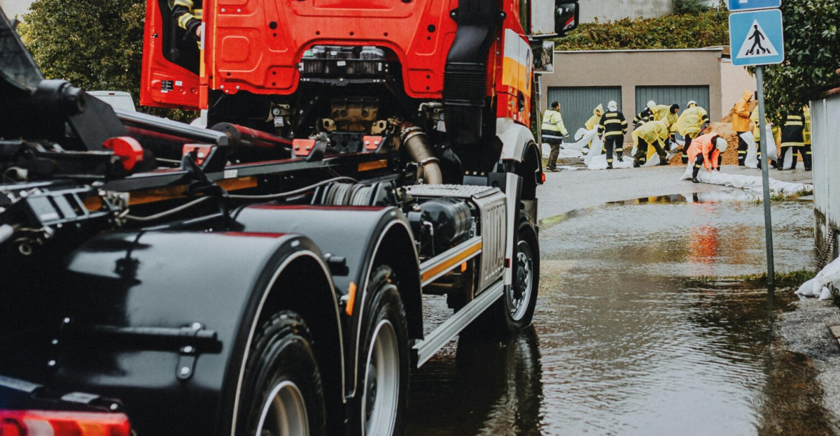 Emergency vehicles and personnel addressing urban flooding caused by heavy rains.