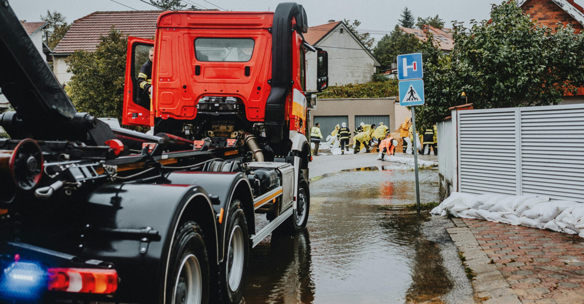 Emergency vehicles and personnel addressing urban flooding caused by heavy rains.
