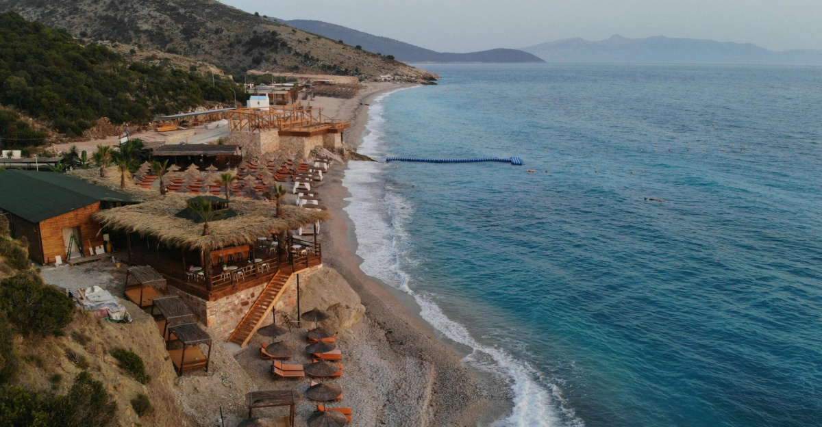Stunning aerial shot of a serene beach resort in Albania, featuring turquoise waters and scenic coastline.