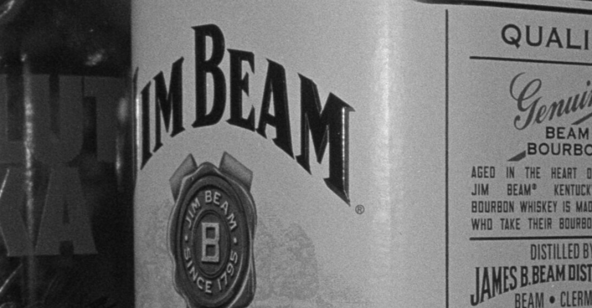 Black and white image of Jim Beam and Absolut Vodka bottles showcasing labels.