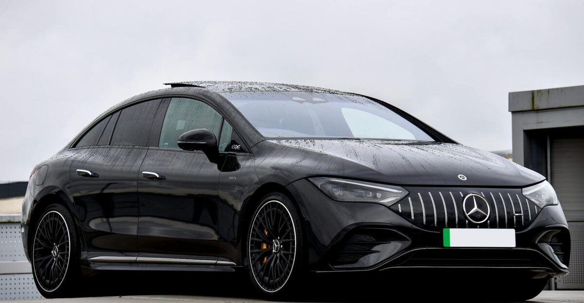 A stylish black Mercedes-Benz EQ electric car parked under cloudy skies showcasing modern automotive design