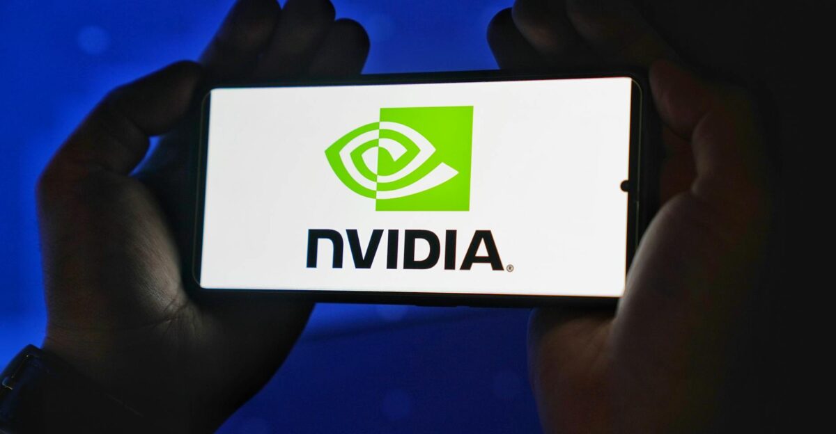 Hands holding a smartphone showing the NVIDIA logo on a bright screen