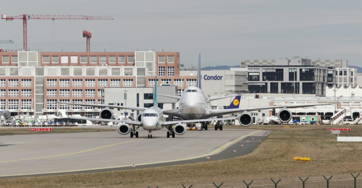 Airplanes at Frankfurt Airport wait on the runway amidst busy terminal activity