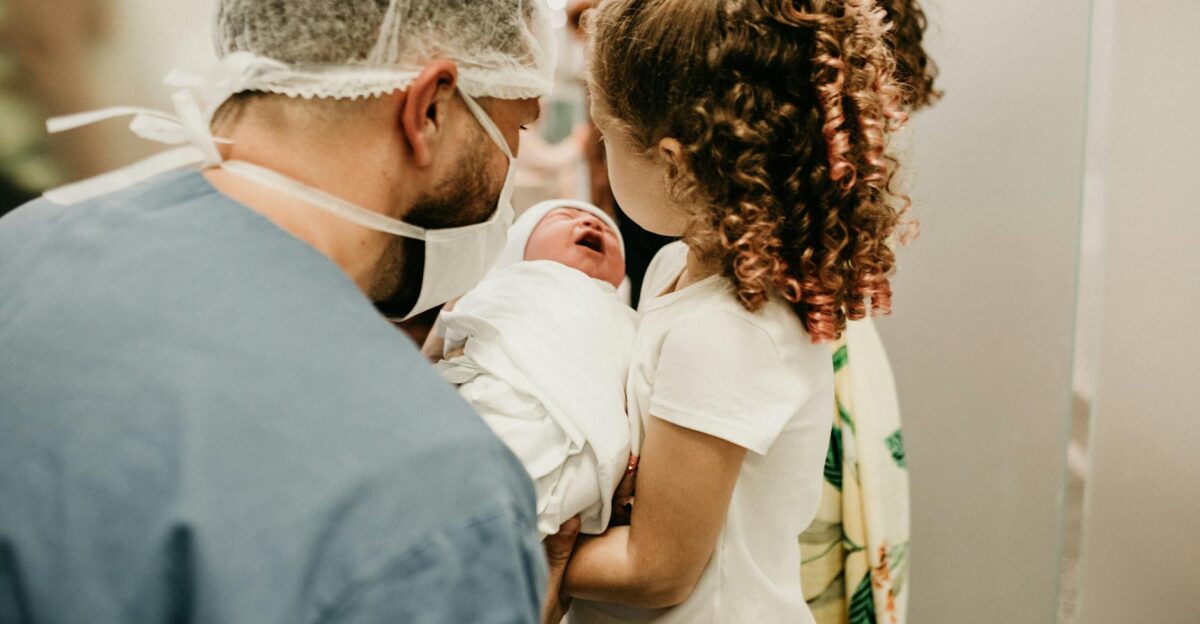 A happy family moment as a young girl meets her newborn sibling in the hospital