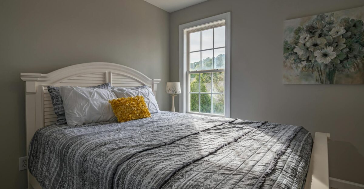 A warm inviting bedroom with a double bed and natural light streaming in