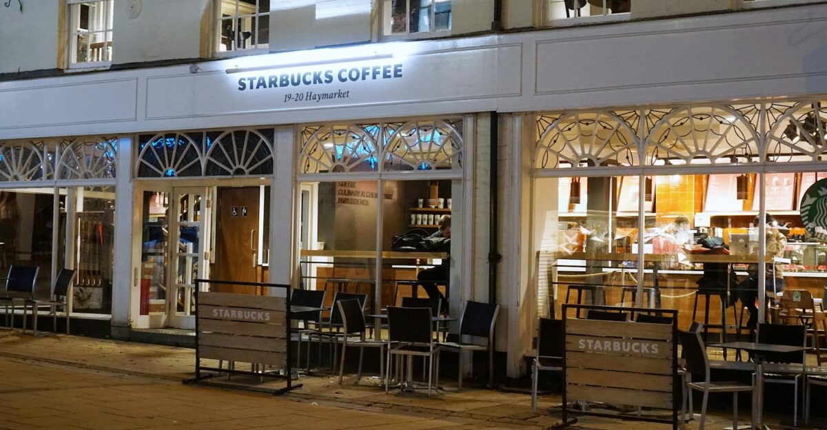 A cozy Starbucks caf in Norwich with inviting exterior lights and seating at night