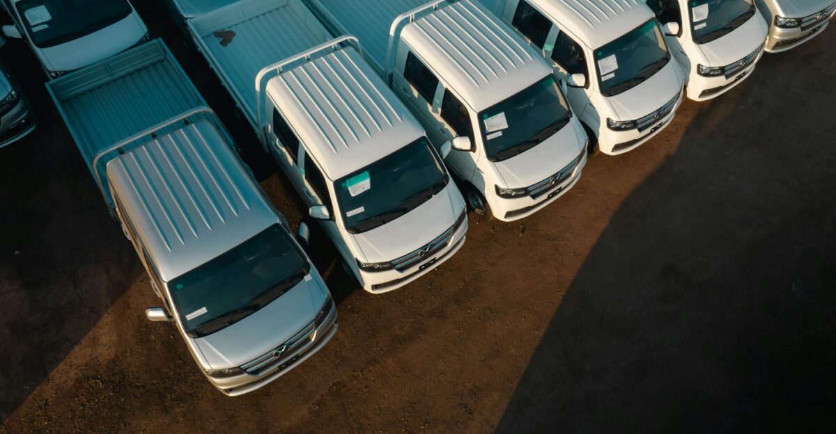 Aerial view of white pickup trucks aligned neatly in a parking lot High contrast lighting