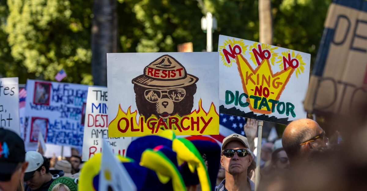 Dynamic protest scene in Sacramento highlighting political dissent with anti-oligarchy signs