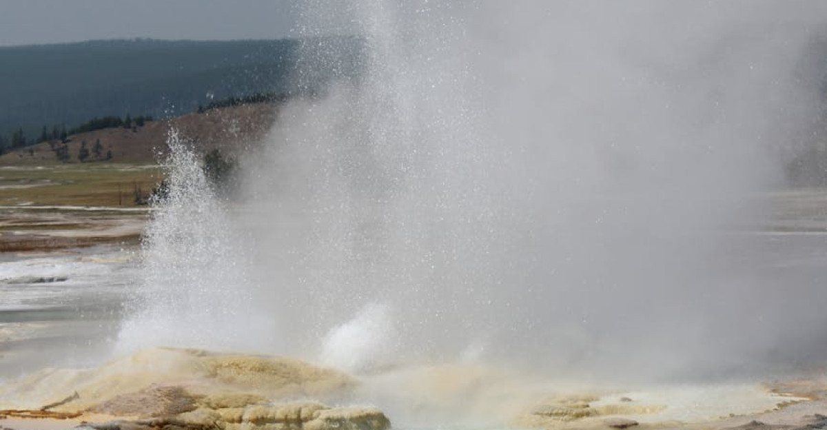 Steam and water erupts from a geothermal geyser in Yellowstone National Park s stunning landscape
