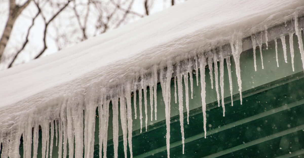 Winter scene of icicles hanging from a rooftop after heavy snowfall