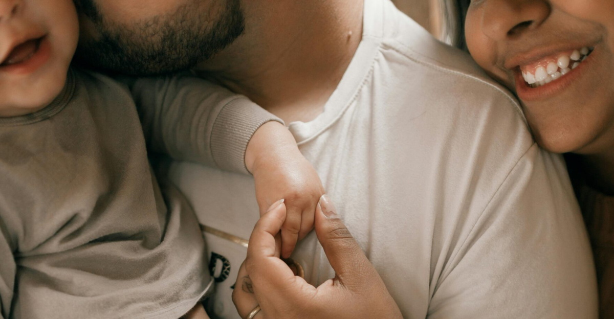A loving family scene with parents holding a baby, captured in a warm, intimate setting.
