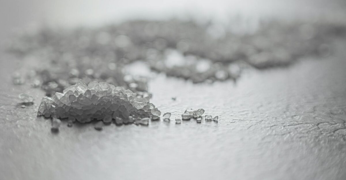 Detailed shot of coarse rock salt scattered on a textured surface