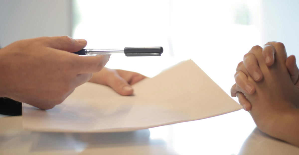 Close-up of a contract signing with hands over documents. Professional business interaction.