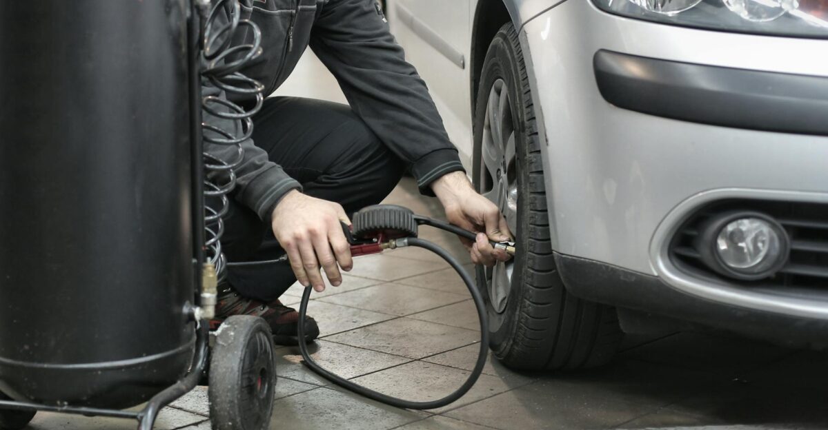 Mechanic inspecting and adjusting tire pressure in an auto repair shop