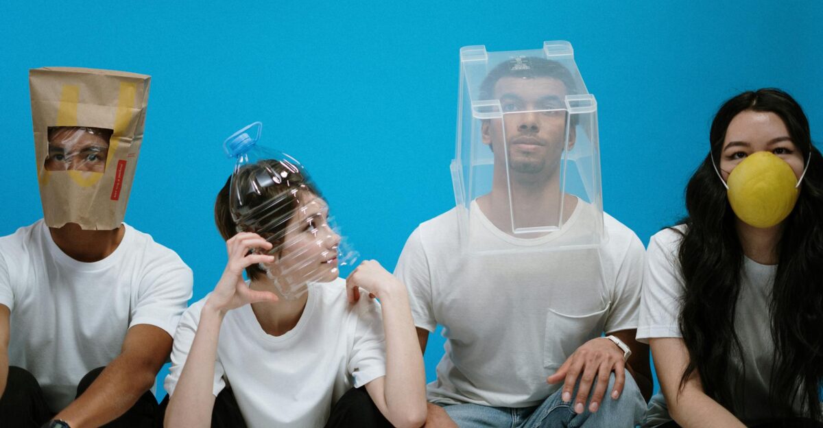 Four people wearing humorous DIY face masks against a blue background showcasing creativity and humor