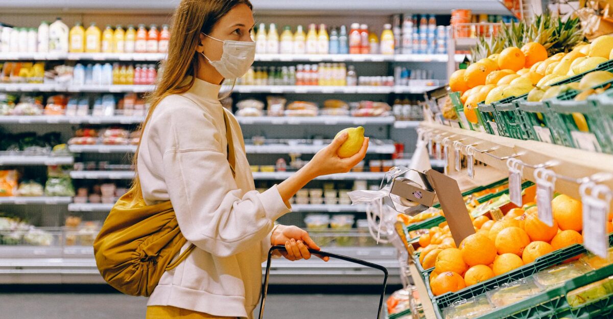 A woman wearing a face mask shops for fruits in a supermarket during a pandemic