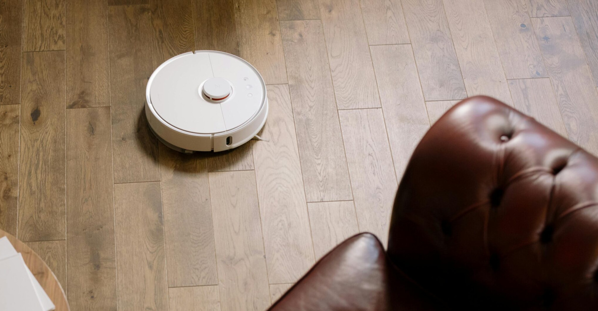 A modern living room with a robotic vacuum and a woman resting, showcasing ease and comfort.