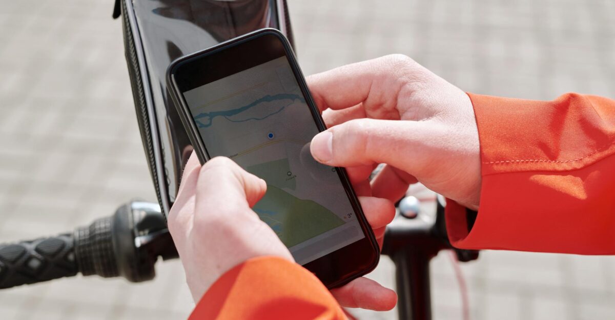 Close-up of cyclist using a smartphone GPS navigation app on a bike mount outdoors
