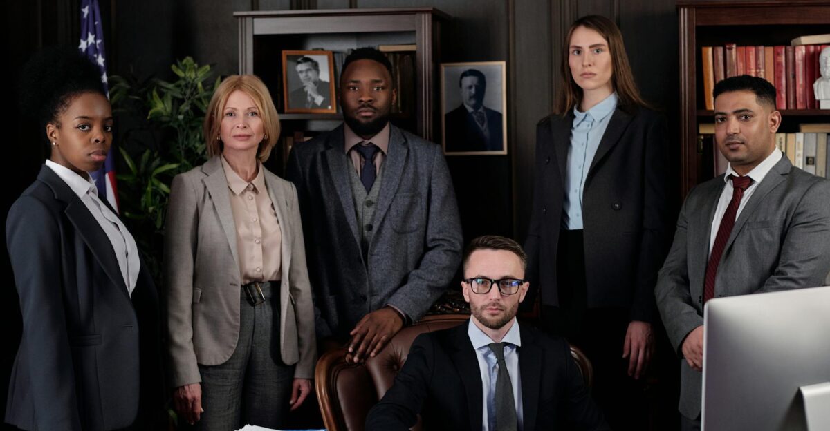 A diverse group of business professionals posing in an office showcasing teamwork and leadership