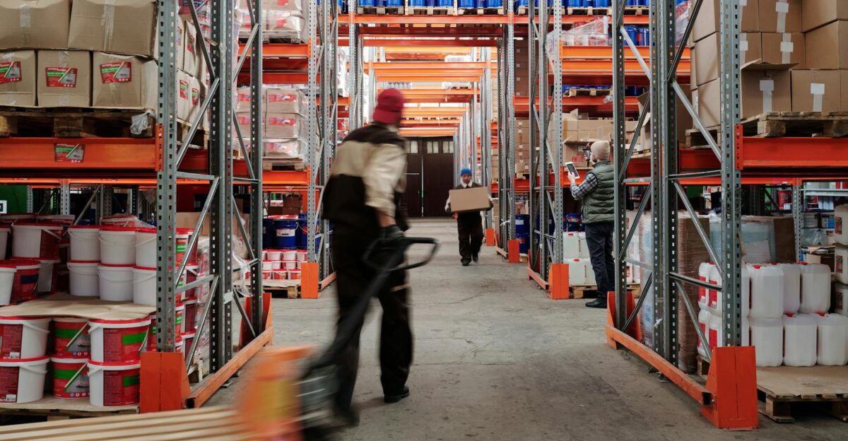 Warehouse interior with workers organizing shelves full of boxes and containers