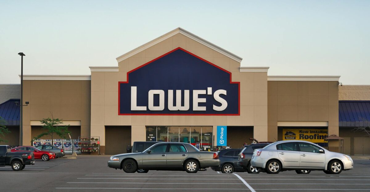 Front view of a Lowe s store entrance with parked cars in the lot during the day
