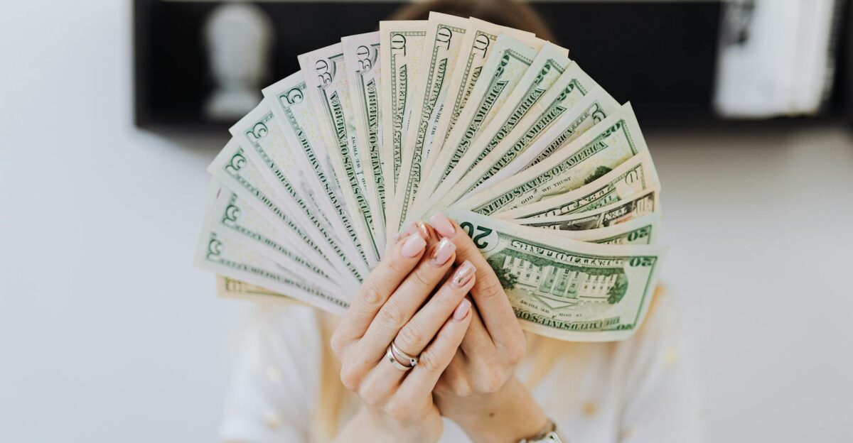 Close-up of hands holding a fan of US dollar bills showcasing financial abundance