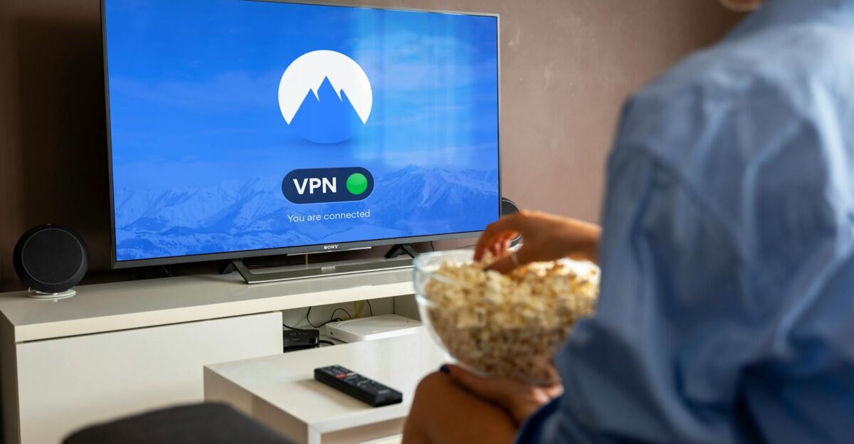 A relaxed scene at home with a person enjoying popcorn while watching a VPN-protected TV