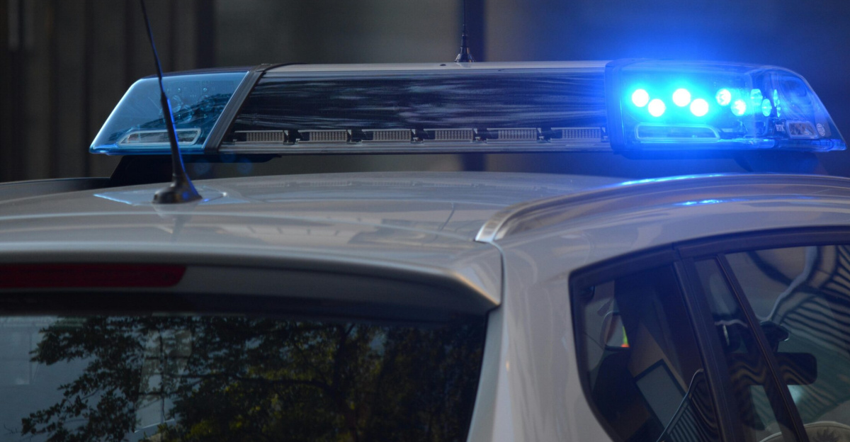 Close-up of a police car's flashing blue lights in an urban environment.