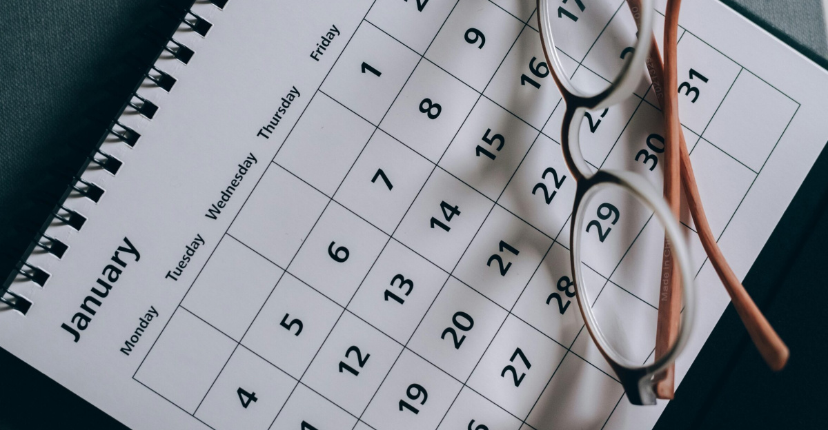 A close-up of a January calendar with eyeglasses on a table, emphasizing planning and organization.