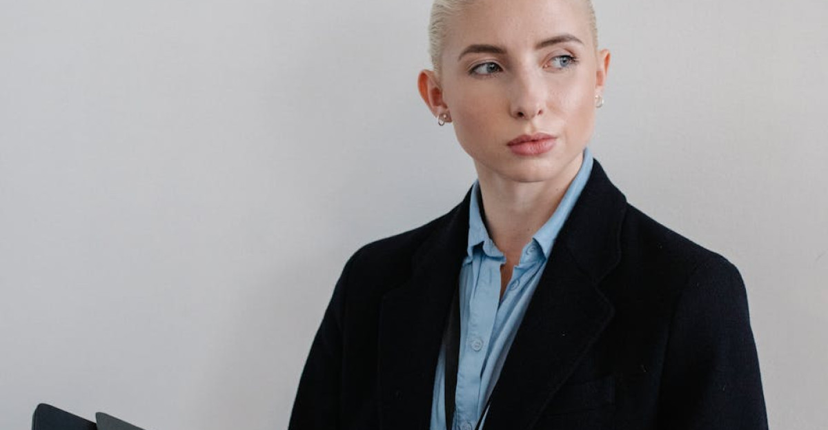 Confident businesswoman in a corporate setting holding a folder looking thoughtfully to the side