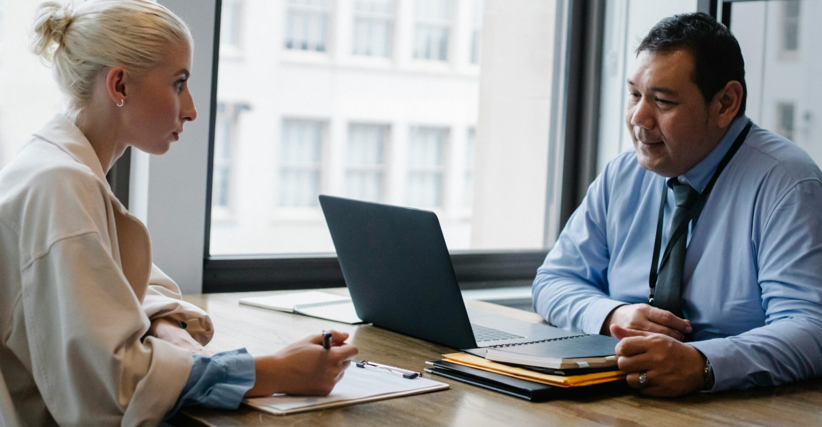 Two professionals engaged in a job interview discussion in a modern office setting.