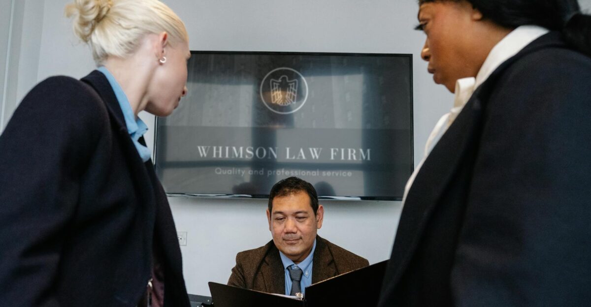 Diverse colleagues gathering in conference hall of law firm and discussing details of contract while working together