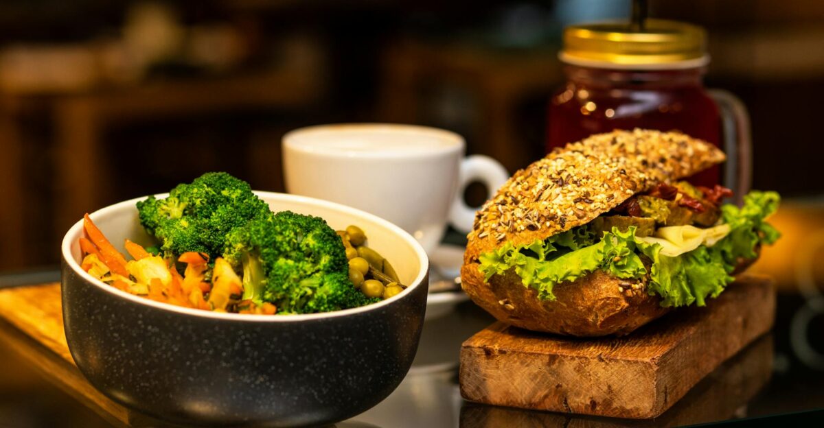 Delicious vegan meal featuring a vegetable sandwich and broccoli salad with a cup of tea