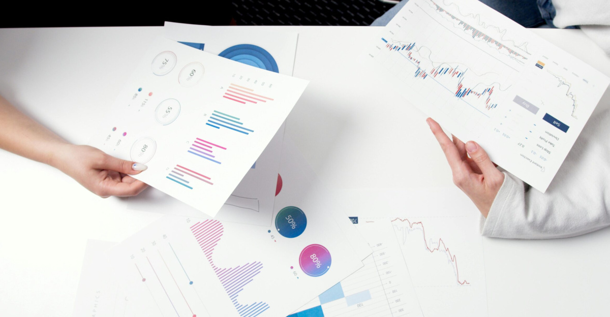 Hands holding business charts and graphs during a meeting, showcasing financial analysis and investment strategy.