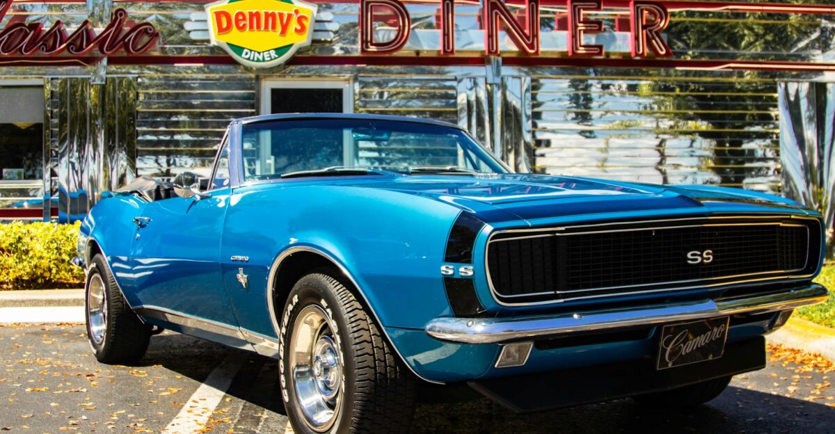 Vintage blue Chevrolet Camaro parked in front of Denny s Classic Diner under sunny skies
