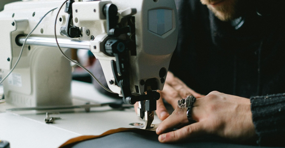 Close-up of hands using an industrial sewing machine to create garments.