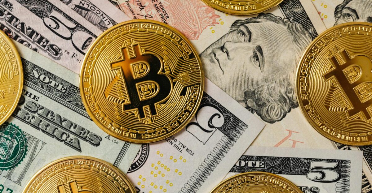 Golden bitcoins on a background of US dollar bills representing cryptocurrency and traditional money