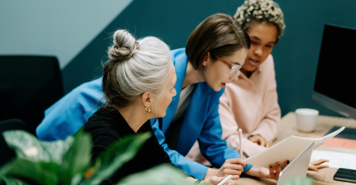 A diverse group of professionals collaborate on a project in a modern office environment.