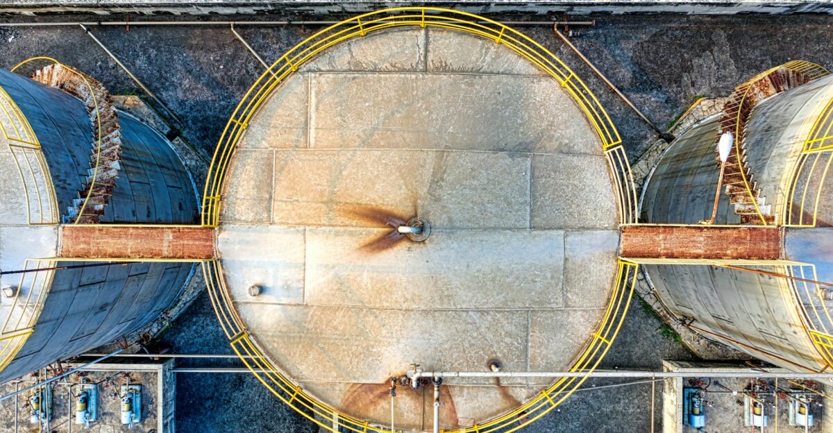 Top view of huge industrial tanks connected with rusty passages located at territory of factory