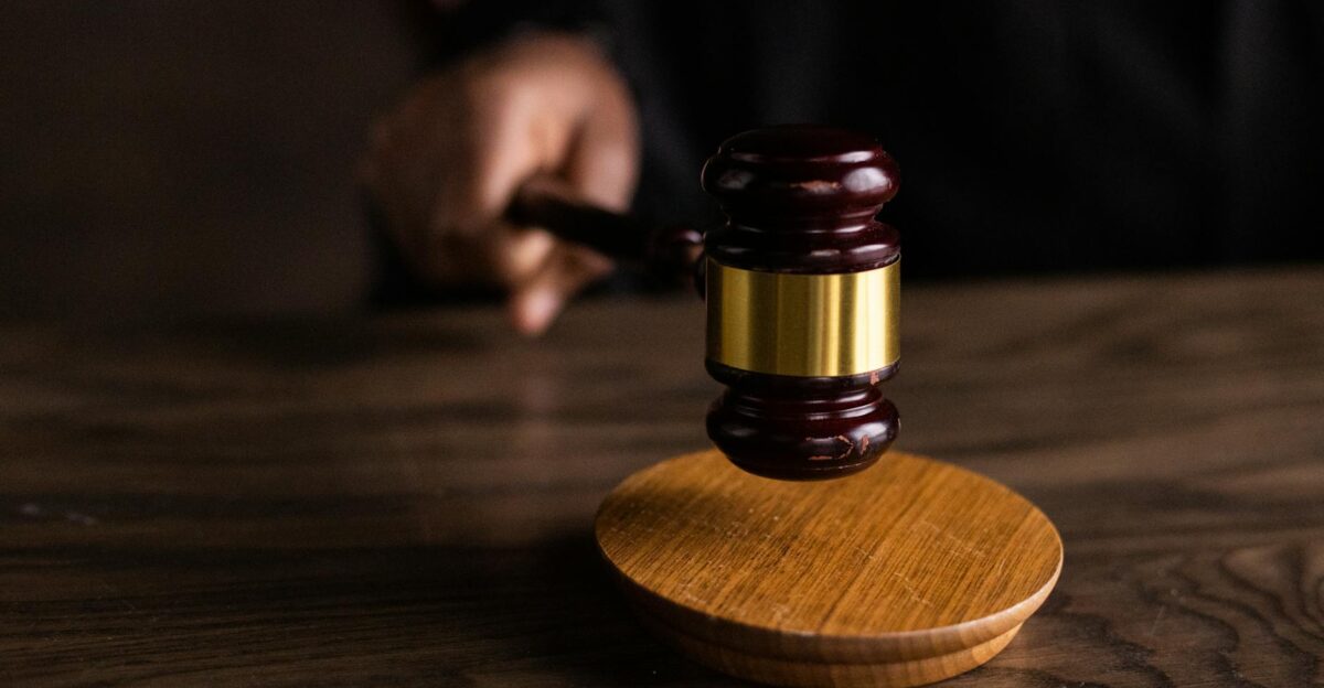 A gavel striking a sound block symbolizing justice and legal authority in a courtroom setting